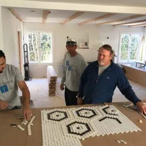 Willy and the Hughes Tile crew laying out a black and white hexagon penny-tile mosaic