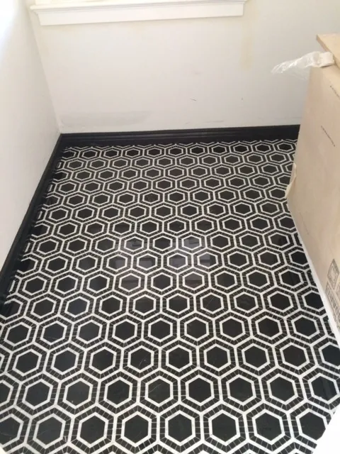 Black and white hexagon-pattern floor tile with a black baseboard