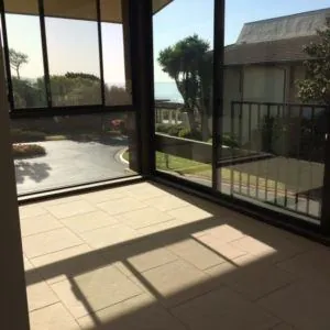 Large-format stone floor tile in a sunroom with floor-to-ceiling windows