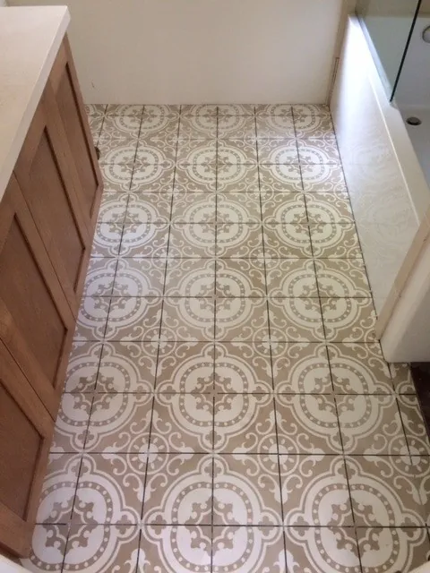 Beige and white patterned cement tile floor in a laundry room