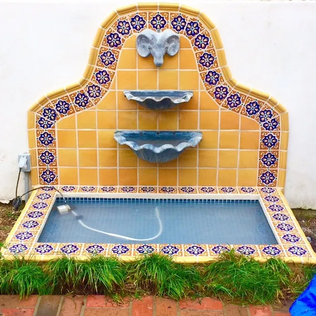Spanish tile wall fountain in yellow and cobalt blue with a tiled pool basin