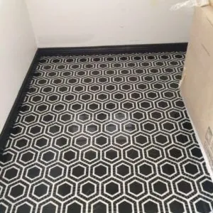 Black and white hexagon-pattern floor tile with a black baseboard