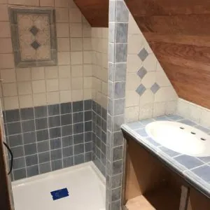 Bathroom remodel in progress with blue and white tile, diamond inlays and a tiled vanity