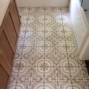 Beige and white patterned cement tile floor in a laundry room