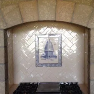 Range niche in white herringbone tile with a Delft-style tile accent under a stone arch