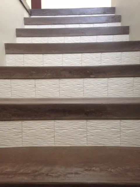 Stair risers in white wave-textured tile with wood-look tile treads