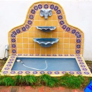 Spanish tile wall fountain in yellow and cobalt blue with a tiled pool basin