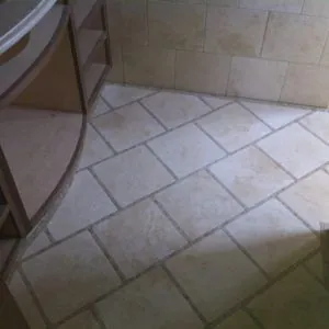Diagonal limestone bathroom floor tile with a matching tiled wall