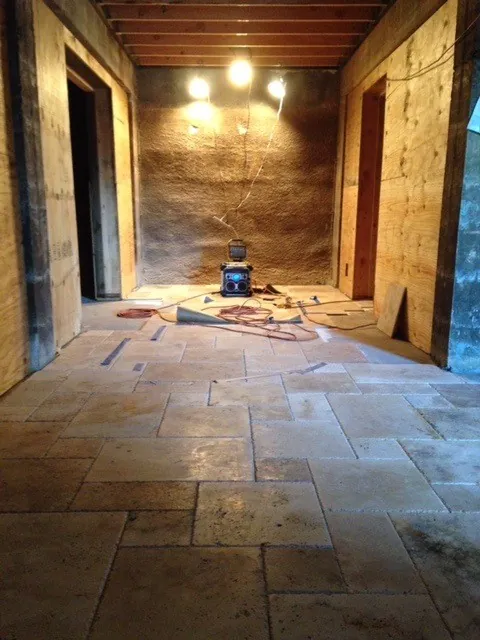 Rustic travertine floor tile in a wine cellar with rough wood walls