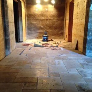 Rustic travertine floor tile in a wine cellar with rough wood walls
